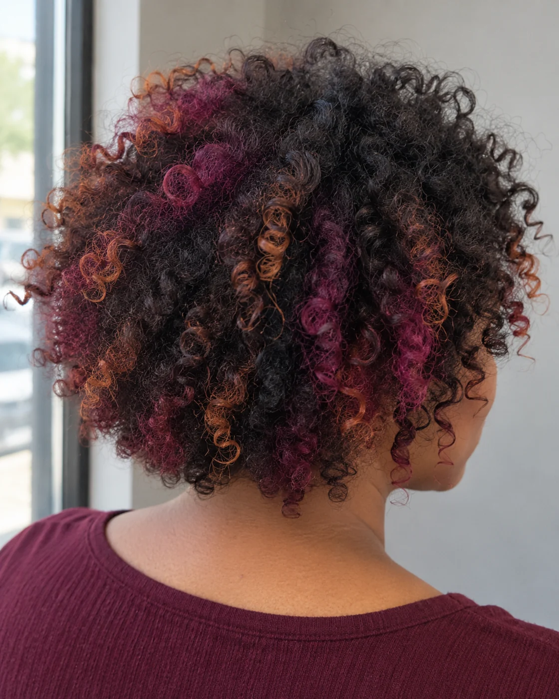 Magenta and copper accents through natural curls